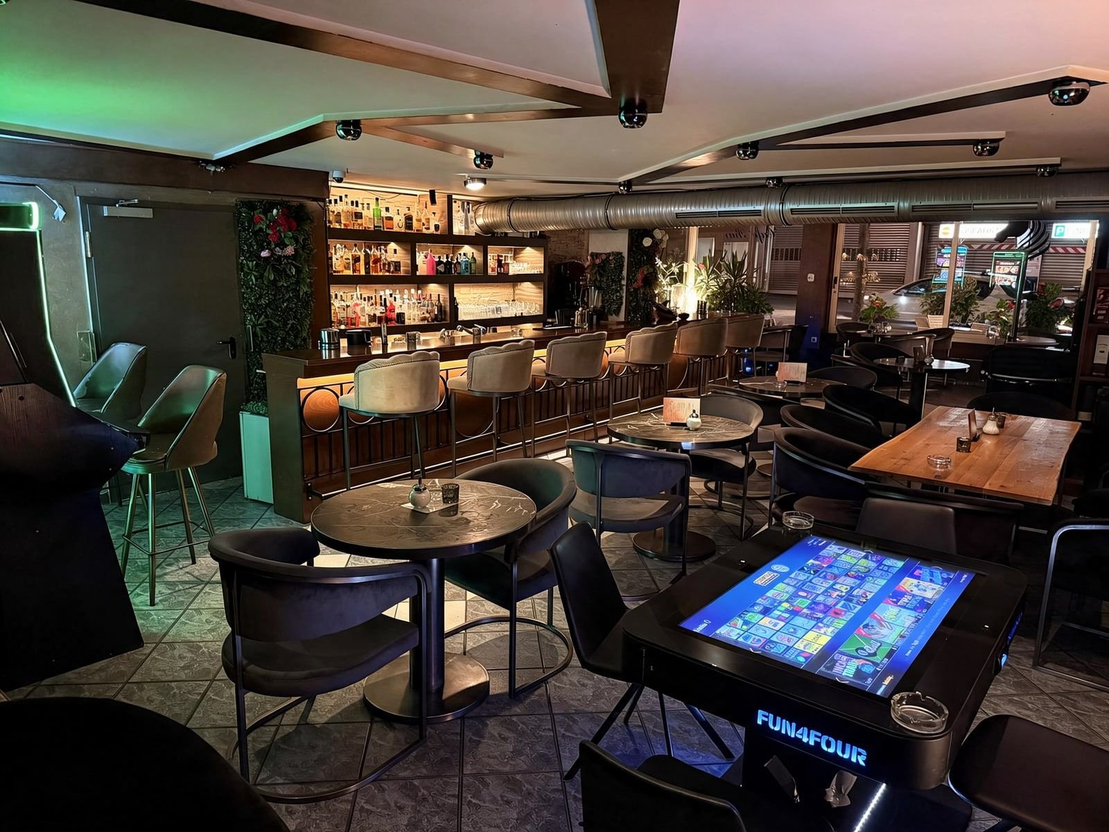 Gastraum mit Spieltisch im Vordergrund und Bar im Hintergrund